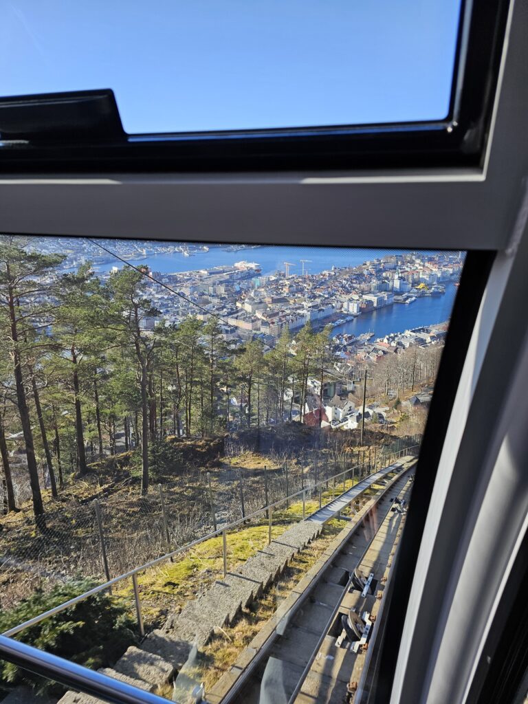 Bergen getting smaller beneath you as the funicular climbs Mount Fløyen.